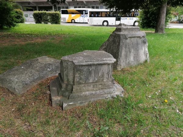 Trije nagrobniki nekdanjega pokopališča v bližini avtobusne postaje.