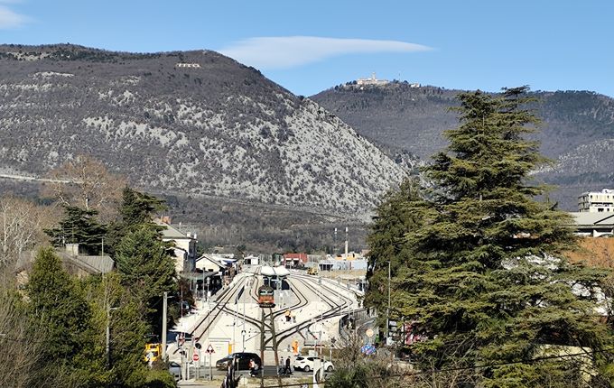 Železniški tiri s postajo, v ozadju Sabotin in Sveta gora. Foto: Blaž Kosovel.  